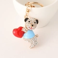 Llavero de osito de peluche con pedrería sosteniendo un corazón rojo fondo blanco - Azul