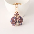 Portachiavi a scarabeo dorato con cristalli viola e blu su una tazza di ceramica - Viola