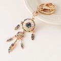 Golden dreamcatcher keychain with multicolored crystals and dangling feather charms - Multi-color