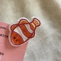 Makro-Detail einer süßen orangefarbenen Clownfisch-Haarklammer aus glattem Acryl - Clownfisch-Clip