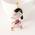 Sparkling crystal puppy riding scooter keychain with rhinestones in golden alloy finish - Pink