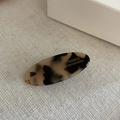 Dettaglio del fermaglio per capelli in acetato tartarugato con scritte dorate - Leopardo Chiaro