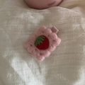 Makroaufnahme einer Wollfilz-Erdbeere-Haarklammer mit rosa Wellenrand auf Stoff - Rosa Erdbeere
