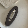 Dettaglio del fermaglio ovale opaco con molla in metallo su piatto di ceramica - Fermaglio per Capelli Ovale Grigio