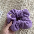 Close-up of purple towel fabric scrunchie with engraved golden handmade metal tag - Purple