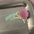 Dettaglio del fermaglio in feltro verde menta con pompon rosa e decorazione a fiocco crema - Sfera Grande Rosa con Clip Verde