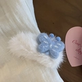Dettaglio di un fermaglio per capelli in peluche bianco con farfalla in feltro azzurro - Bianco