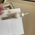 Handheld view of a Korean style hair clip with creamy beads and white pearls on card - Milk Tea Ball Pearl Duckbill Clip
