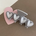 Detail view of large gray hair claw clip with white-outlined 3D heart patterns - Gray Heart With White Edge