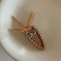 Detail of a handmade brown knitted hair clip with cute cartoon eyes on a ceramic plate - Light Coffee Carrot Knitted Hair Clip (6#)