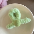 Vue de dessus d'une pince à cheveux en peluche vert clair avec pompon dans un bol blanc - Vert Croisé Pompon Vert