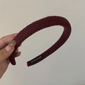 Dettaglio ravvicinato di una fascia in maglia bordeaux con etichetta fatta a mano - Rosso Mattone