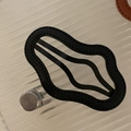 Black faux leather wave-edged cloud hair clip with visible stitching on glass background - Black