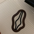 Brown leather wave-shaped hair clip with fine stitching and black metal base - Khaki