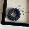 Detail of dark blue spiral hair tie with a soft fuzzy texture and elastic cord design - Navy Blue
