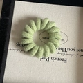 Detailed view of a light green candy-colored spiral hair tie with a soft knitted wool texture - Turquoise Green
