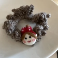 Detail of grey knitted hair tie with cute wool felt doll head and polka dot bow - Grey Girl