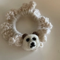 Close-up of handmade cream crochet hair tie with a cute knitted brown bear mascot - White Panda Off-White
