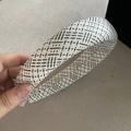 Detail eines schwarz-weiß karierten Tweed-Haarreifs aus dickem Schwamm-Gewebe - Weiß Stirnband Schwarz Streifen