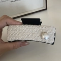 Close-up of white tweed fabric texture and large pearl detail on a hair claw clip - Beige Style