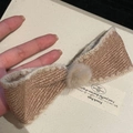 Détail de la barrette à nœud en tweed avec pompon en peluche et bords festonnés - Grande Barrette Nœud Thé Au Lait