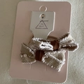 Vue détaillée de deux barrettes à nœud en velours beige et marron sur carton rose - Chouchou Nœud Bordure Fourrure Beige (Paire)