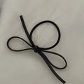 Close-up of a black bow hair tie featuring high-elastic material on a textured background - Black Bowknot Hair Tie / Black