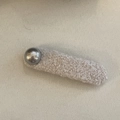 Close-up of a large oat-colored plush hair clip featuring a glossy metal button detail - White