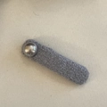 Detail view of a dark grey plush hair clip with a silver bead decoration for women - Gray