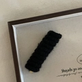 Macro detail of a black knitted wool hair clip featuring a 3D wavy texture and metal core - Black Spring Hair Clip