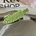 Detalle de pinza para el pelo ondulada verde aguacate sobre bandeja con acabado mate - Verde