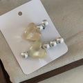 Dettaglio di eleganti fermagli per capelli con cuori gelatina e perle su sfondo strutturato - Stile Perla Cuore Beige
