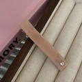 Primer plano de un pasador rectangular de resina rosa palo con un detalle de strass perlado - Clip de Pico de Pato Café Con Strass
