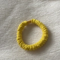 Macro detail of elastic yellow scrunchie texture with matching plastic fastener - Ginger Yellow Hair Tie