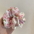 Detail eines floralen Stoff-Scrunchies mit rosa Blumen und hellgrüner Paspelierung - Grüner Rand Rosa Blume
