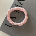 Detalle de un coletero de satén rosa claro con textura plisada y hebilla ovalada - Rosa