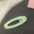 Mint green candy-colored oval hollow hair clip on a minimalist grey and white background - Green