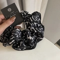 Dettaglio di scrunchie in seta con motivi a inchiostro nero ed etichetta originale - Scrunchie Nero Texture Bianca