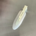Detail view of a matte cream seamless hair clip with metal duckbill base for styling - White