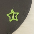 Detalle de una horquilla de estrella de metal verde brillante sobre bandeja de piedra - Verde Brillante