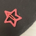Vista detallada de una pinza para el pelo BB de metal rosa con forma de estrella lacada - Rosa fucsia brillante