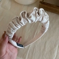 Elegant pleated fabric headband in cream beige color with a glossy satin handmade finish - White