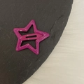 Primer plano de una pinza para el cabello de estrella morada metálica con acabado brillante - Rosa Púrpura Brillante