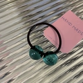 Detalle de goma de pelo negra elástica con dos cuentas de resina verde esmeralda en cartón - Bola Redonda Verde Transparente