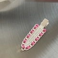 Detail van roze satijnen lint geweven in wit kettingontwerp op een metalen haarklem - Witte Clip met Roze Satijnen Lint