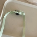 Detailed view of a small black claw clip featuring long mint green satin ribbons - Long Ribbon Bow Style / Green