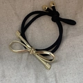 Elegante goma para el pelo negra con charm de lazo metálico dorado pulido y brillo - Estilo Lazo / Dorado