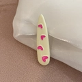 Dettaglio della molletta color crema con cuori rosa su tessuto di organza bianca - Bianco Sporco