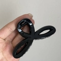Glossy black minimalist hair claw clip with cross-loop design for elegant hair styling - Black