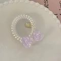 Detailansicht der Spiral-Haargummi mit lavendelfarbener Schleife und goldenem Anhänger - Transparentes Violett